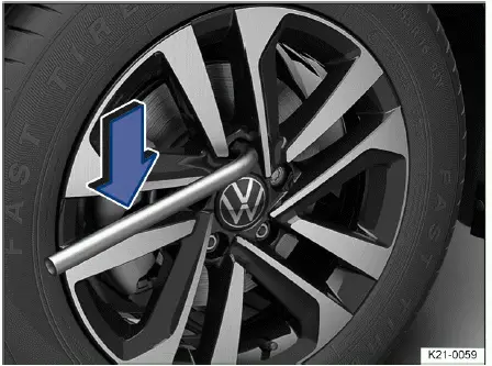 Volkswagen ID.4 removing wheel bolts with lug wrench during wheel change procedure
